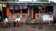 A rural CICO agent sits outside a family home
