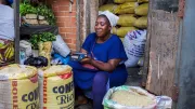 A woman market vendor uses digital finance tools