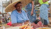 A woman smiles at a market stand