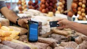 a man making a payment using a credit card machine at a street market