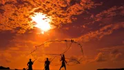 Fishermen with their nets walk in the sunset. Photo by Gayanath Wimaladasa.
