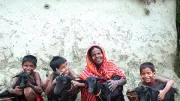 Woman smiles with her children and goats, India