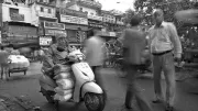 Man on a motorbike talks on a mobile phone, India