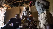 Kenyan smallholder family crowds around a tablet