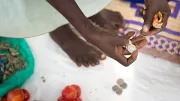 A merchant in rural Uganda transacts in cash