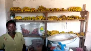 Woman stands next to shelves of bananas, Rwanda