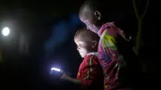 Two boys viewing a flashlight.
