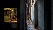 A man looks out through his shop window.