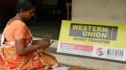 Woman counting money outside of a money transfer station.