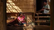 Woman and man weaving with grass.