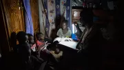 Family reads by PAYGo solar light in Mali
