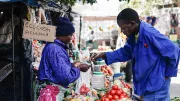 A vegetable seller conducts a mobile money transaction in Bulawayo, Zimbabwe. 