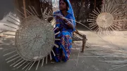 A woman in India weaves a basket