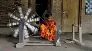 A weaver at her spinning wheel in India.